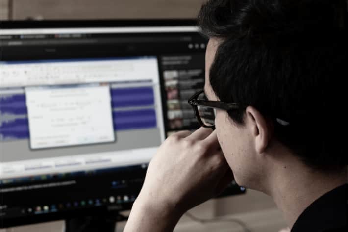 Homem de óculos olhando para a tela do computador com uma janela pop-up