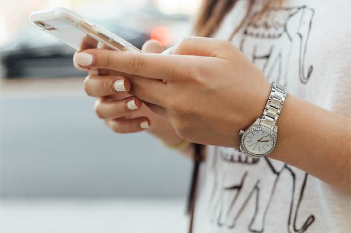 uma mulher procurando vírus para iPhone em seu iPhone.