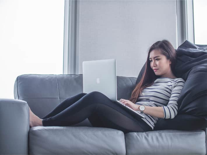 Mulher usando um laptop no sofá