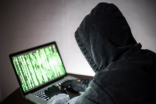 Um homem trabalhando em um computador e irritado ao perceber que foi hackeado